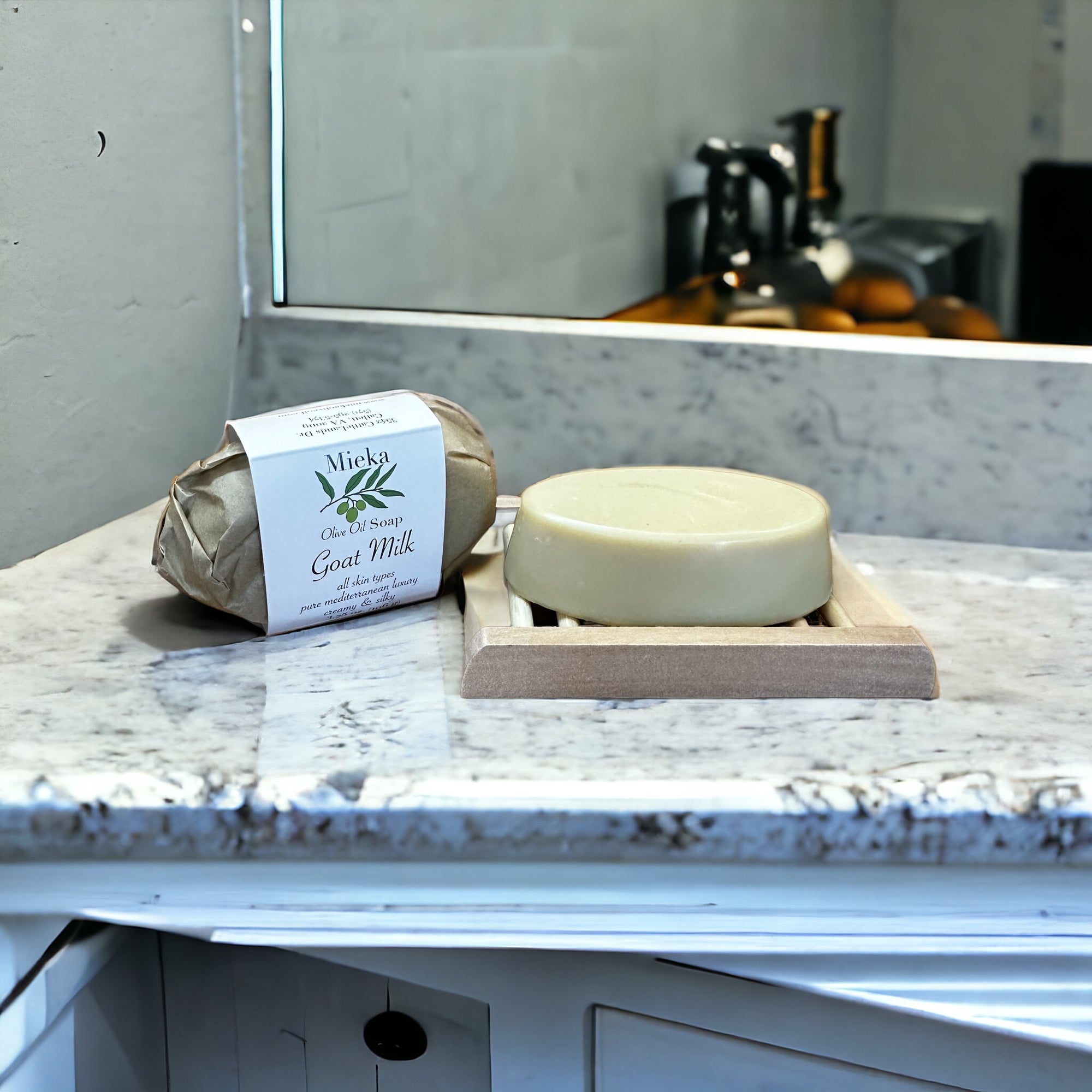 Soap bar and packaged bar of soap sitting on a granite counter top with a mirror in the background