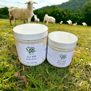 Containers of goat milk lotion in a field with goats