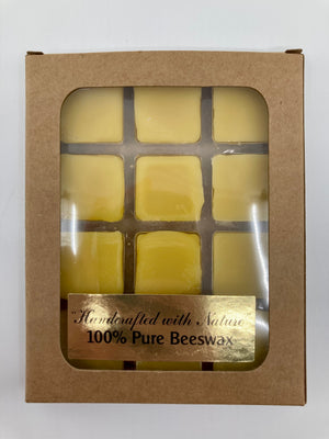Beeswax melts are packaged in a brown rectangular box with a clear window on the front that shows the beeswax melts.  The window also has a gold foil sticker on it that says "Handcrafted with nature 100% pure beeswax".