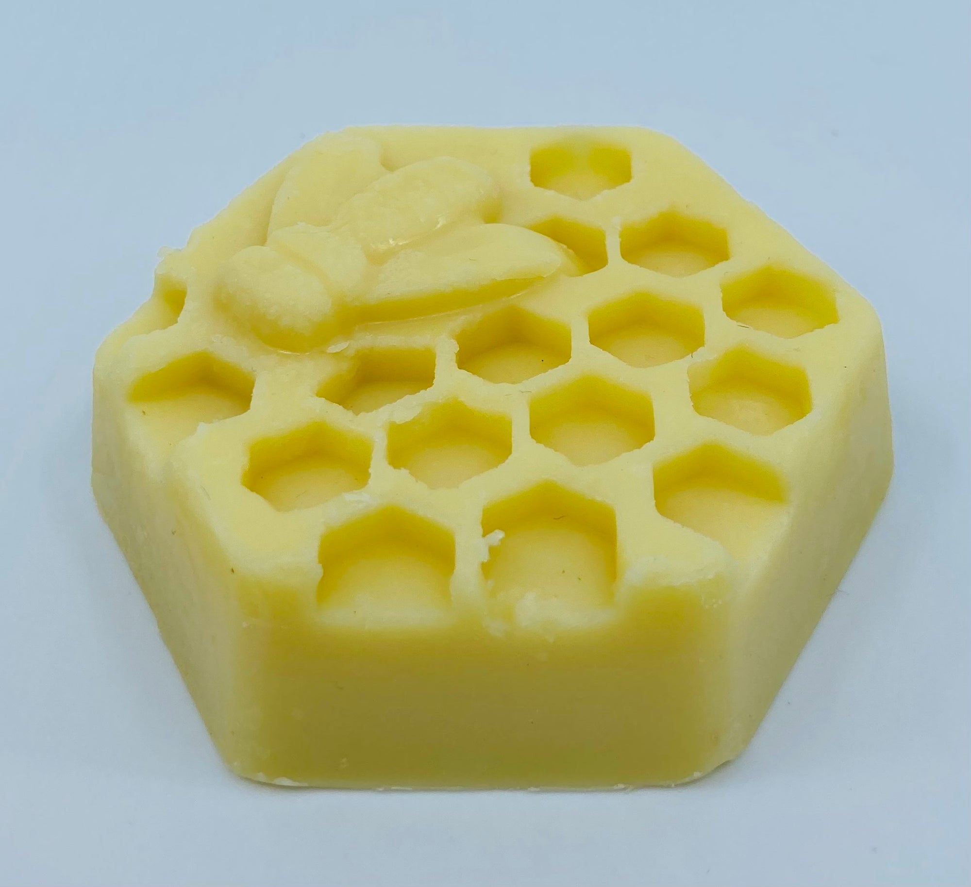 An angled view of the beeswax lotion bar.  Please note that beeswax is a natural resource and there may be variations in color from pale yellow to dark gold.